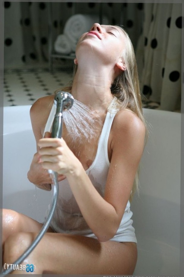 Girl in a little white vest top takes a shower. See more photos here